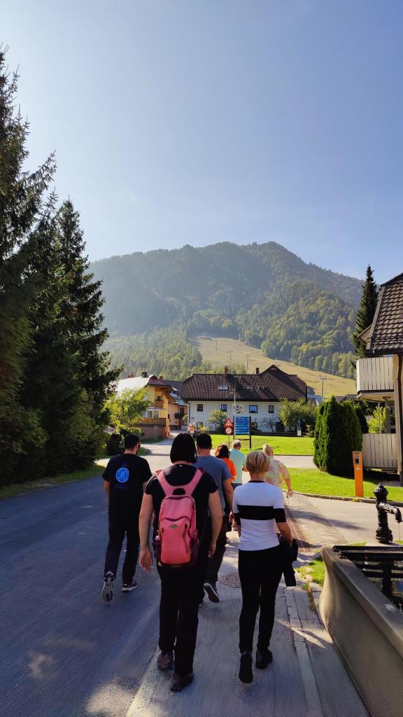 Ihmisiä kävelemässä kadulla. Taustalla vuorimaisema.