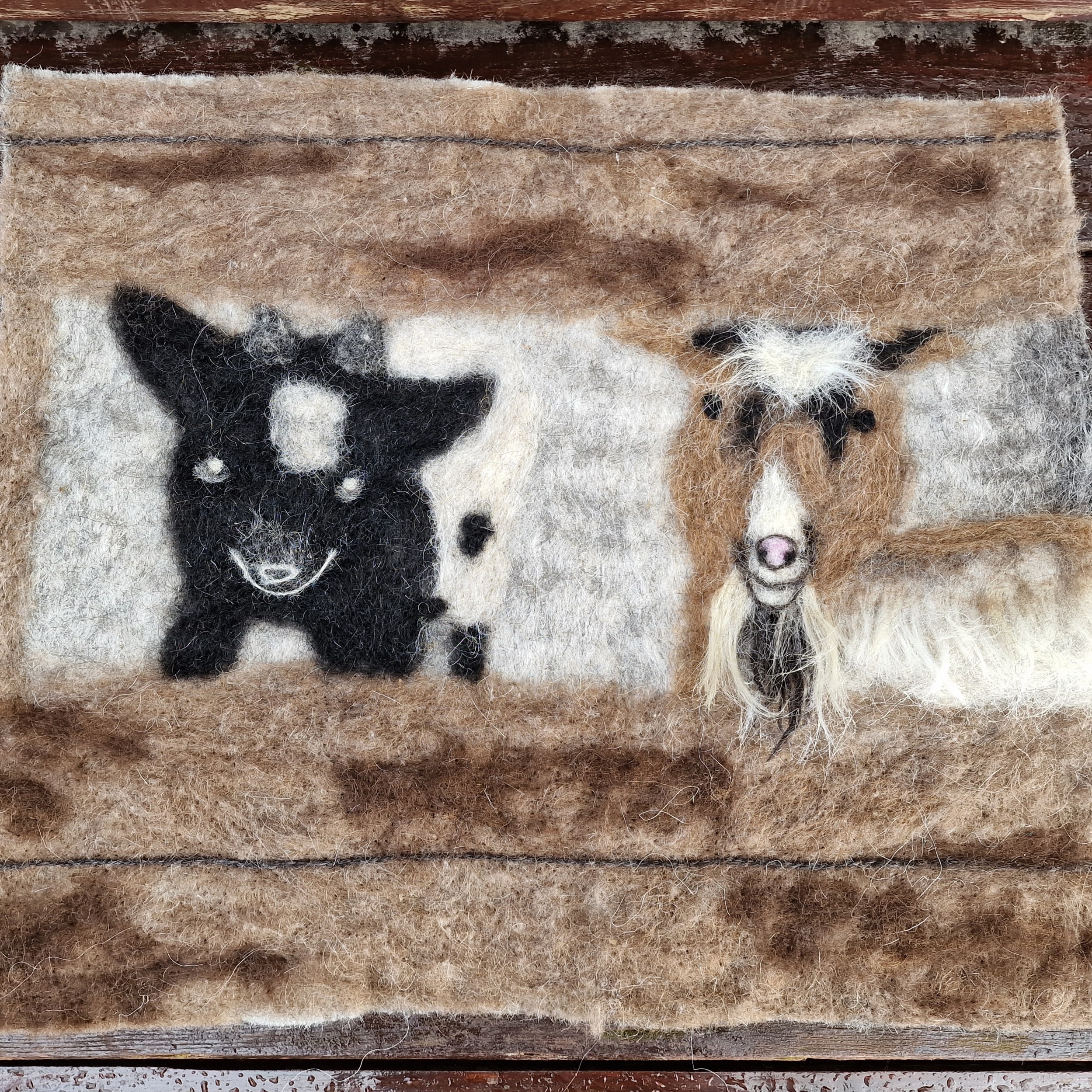 Felted art piece of a goat, and her baby