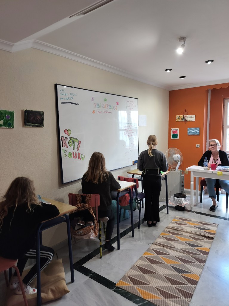 Koululuokassa opettaja ja oppilaita