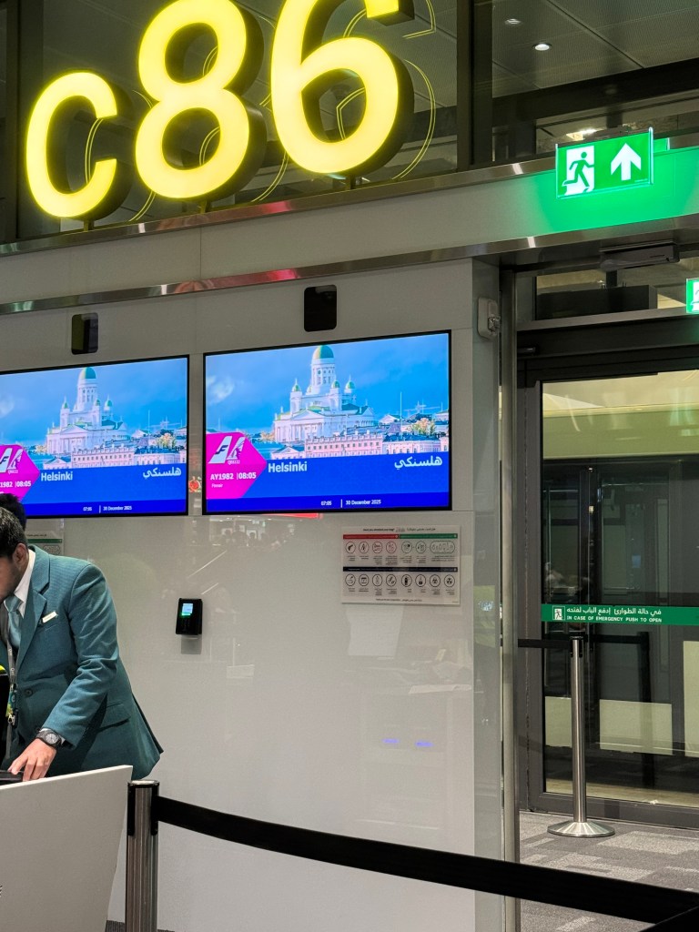 Kuva on lentokentältä boarding gatelta. Kuvassa on TV jossa lukee Helsinki. 