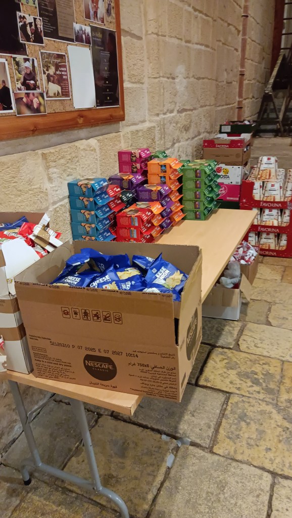 Valmisruoka pakkauksia järjestyksessä pöydällä kirkon käytävällä jaettavaksi vieraille.